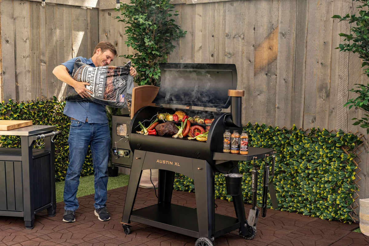 Pit Boss Austin XL pellet grill loaded with meat and vegetables on a garden patio